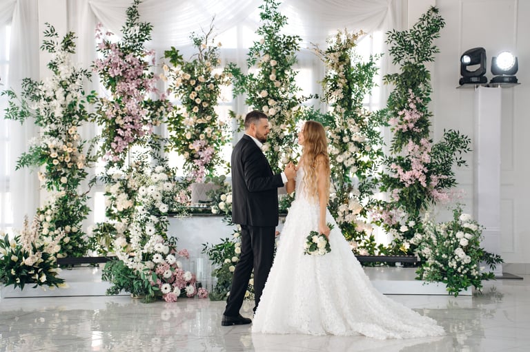 Beautiful newlyweds dancing in decorated banquet hall with flowers