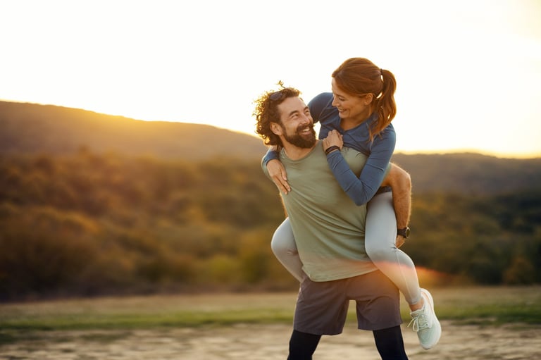 Couple laughing together outdoors at dusk, enjoying golden hour