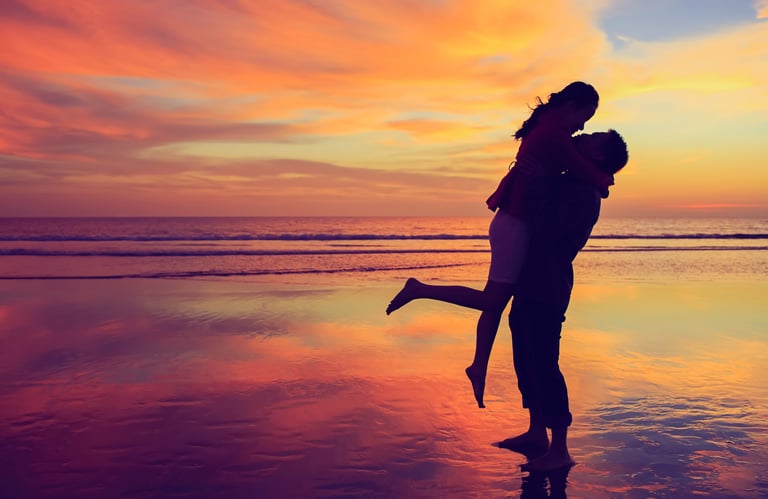 Romantic couple kissing and embracing in sunset golden hour light